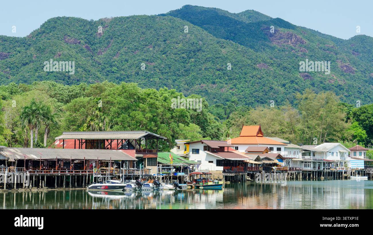 Die Pfahlbauten des Fischerdorfes säumen den Bang bao Pier mit tropischen Bergen in thailand Stockfoto