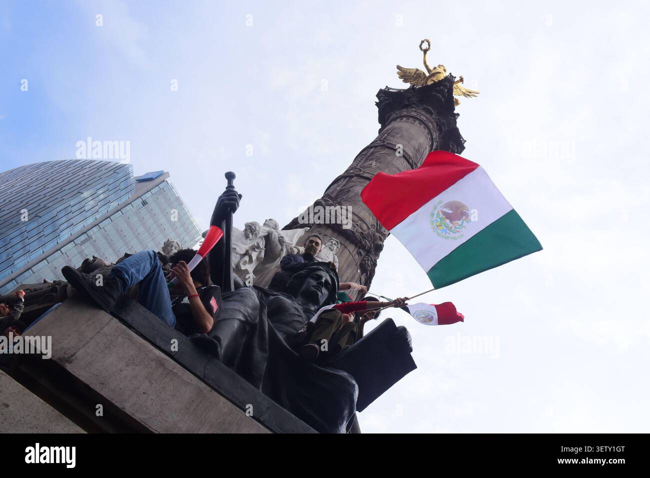Mexikanische Fans klettern während der WM auf die Statuen des Engels der Unabhängigkeit und schwenken Flaggen. Stockfoto