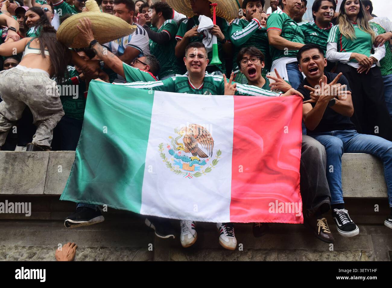 Mexikanische Fans klettern während der WM auf die Statuen des Engels der Unabhängigkeit und schwenken Flaggen. Stockfoto