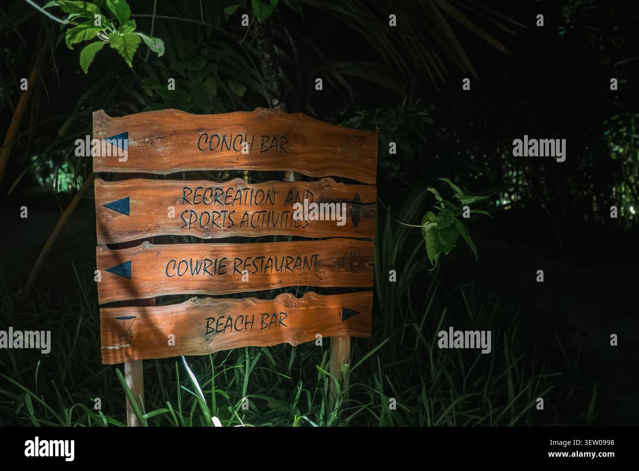 Hölzerne Wegweiser bei Night Points zur Conch Bar, Cowrie Restaurant Stockfoto