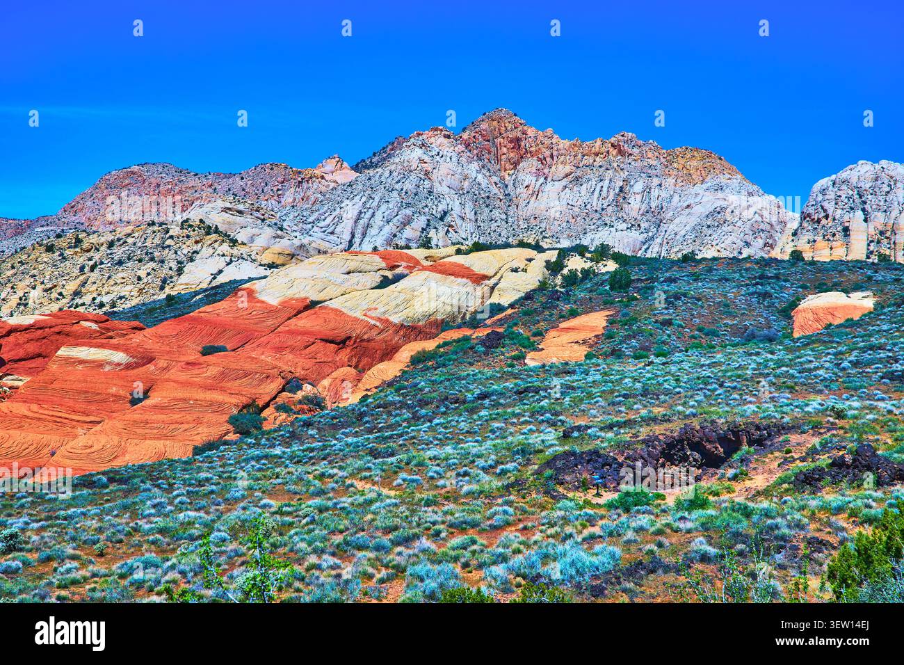 Farbenfrohe Sandsteinformationen und Eingang der Lava Tube im Snow Canyon State Park Stockfoto