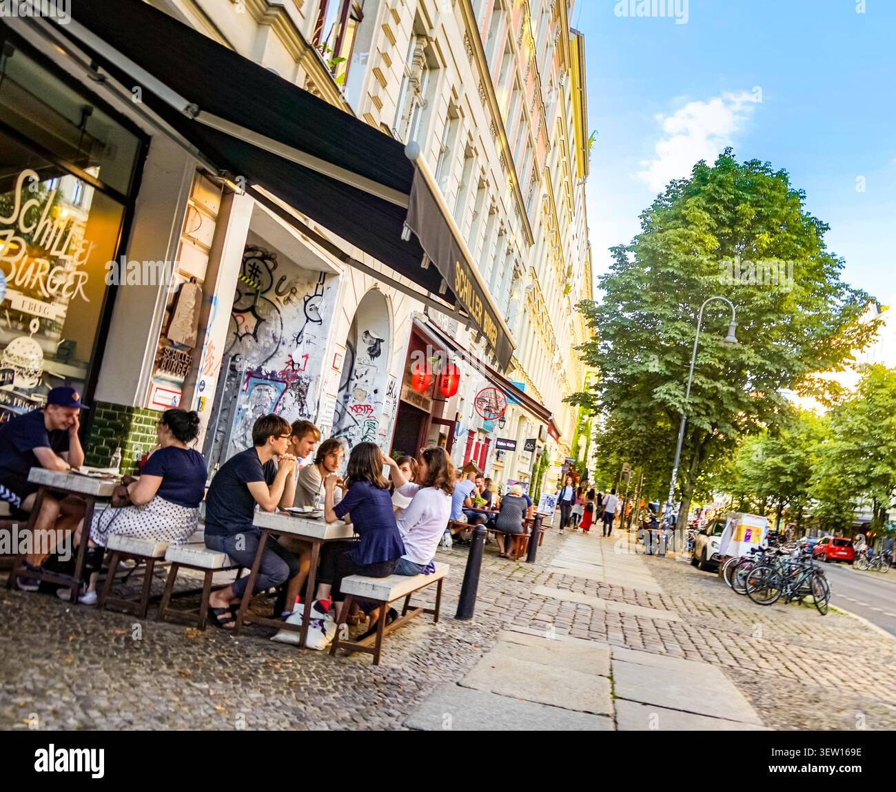 Freunde im Straßencafé im Abendlicht, Rykestraße, Prenzlauer Berg, Berlin, Deutschland Stockfoto