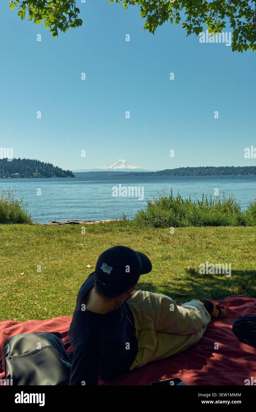Der Bewohner von Seattle genießt einen sonnigen Blick auf den majestätischen Mount Rainier am See und genießt einen ruhigen Moment in der pazifischen Landschaft im Nordwesten. Stockfoto