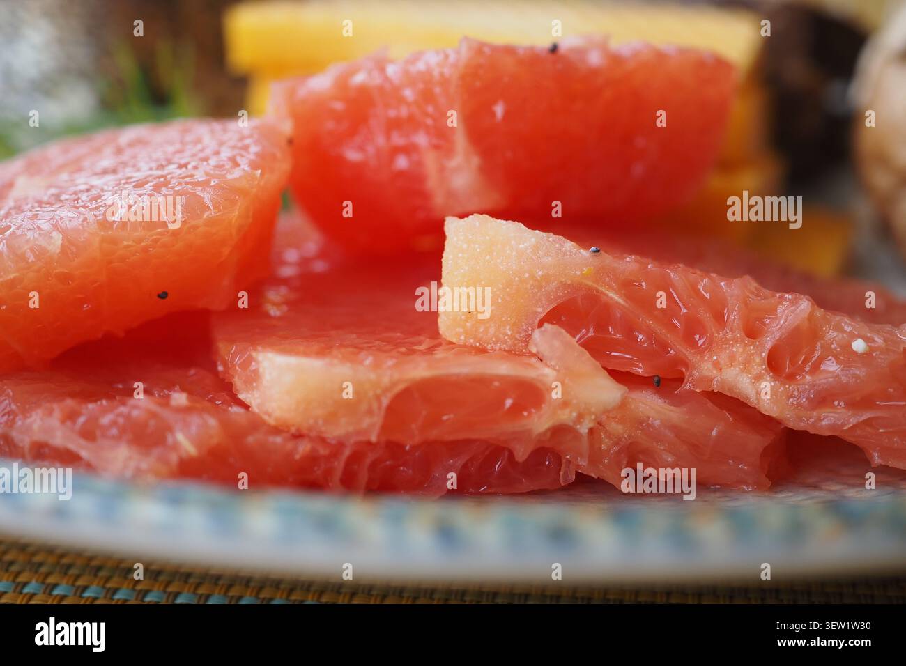 Frische Grapefruitscheiben auf einem Teller mit anderen Früchten Stockfoto
