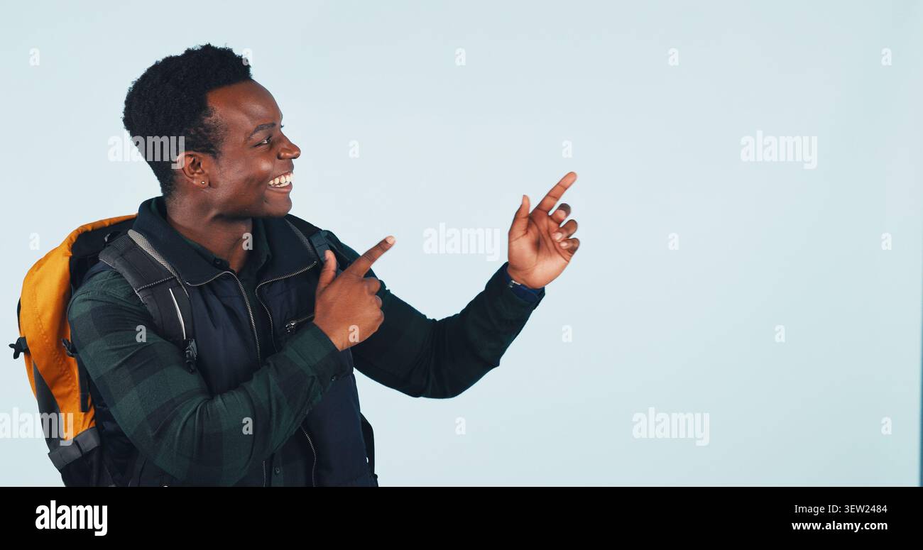 Wandern, Promotion und Happy man im Studio, Zeig- und Reisetipps für Abenteuer oder Empfehlungen. Blauer Hintergrund, Raum und schwarze Person mit Stockfoto