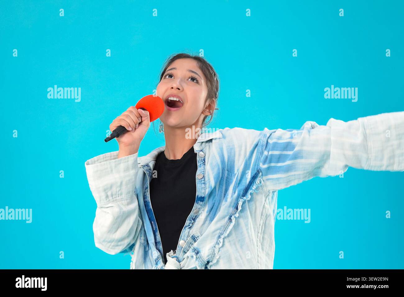 Frau, die heute mit großer Leidenschaft in ein Handmikrofon singt Stockfoto