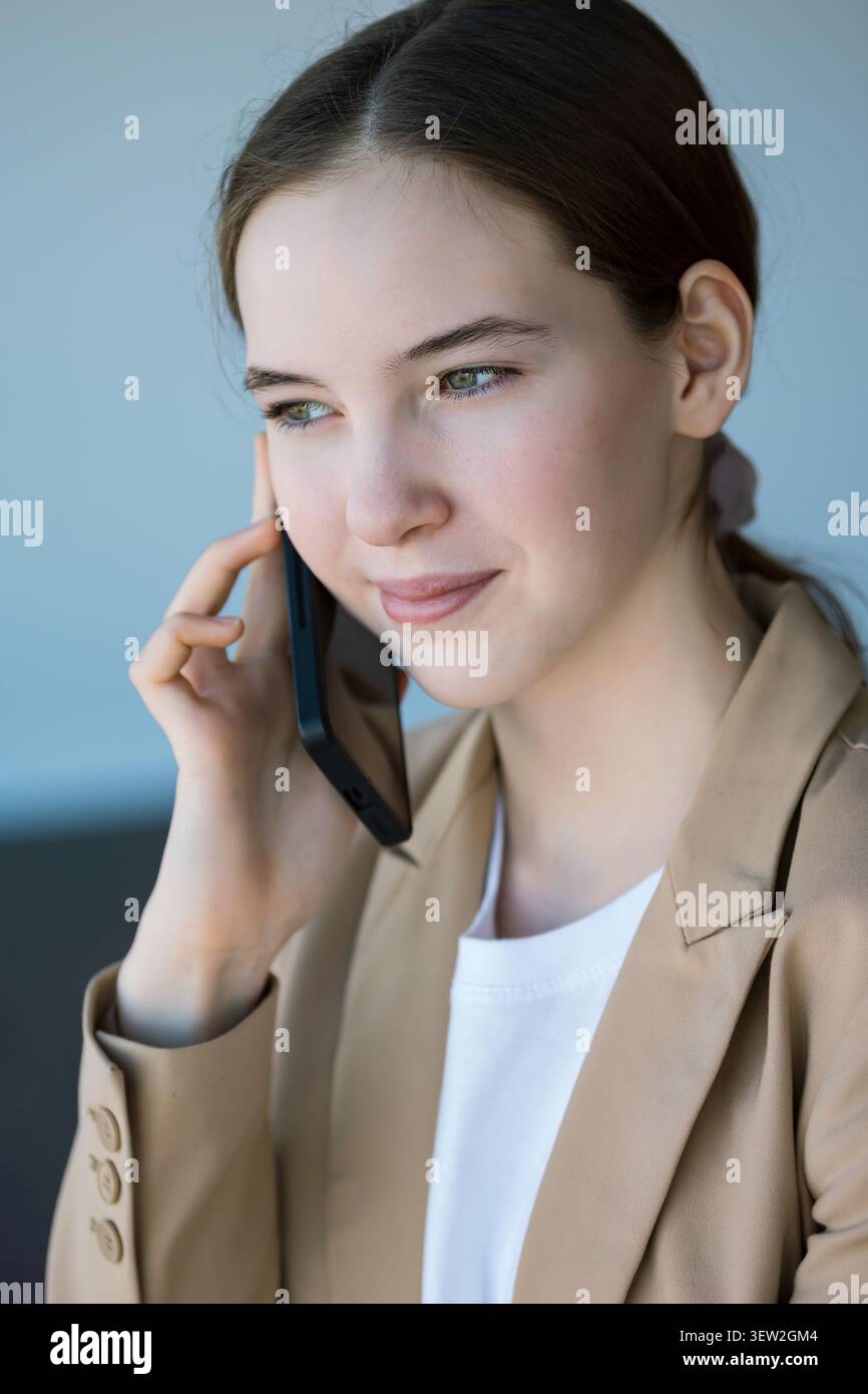Eine junge Kundin, die ansprechende Telefongespräche führt Stockfoto