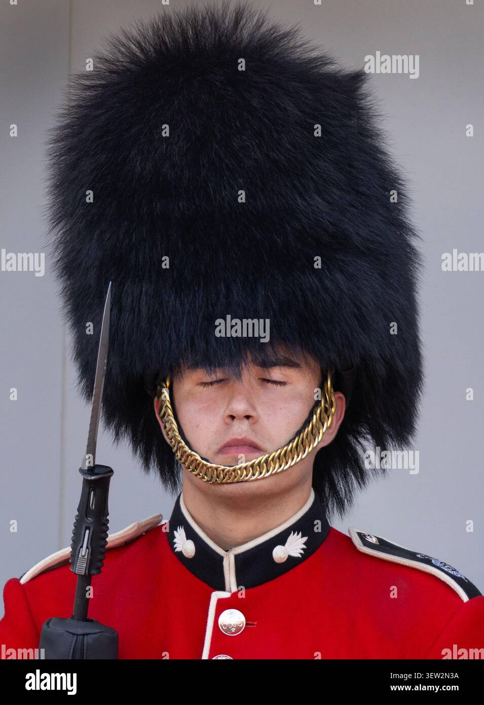 Ein Soldat der Coldstream Guards spürt die Hitze, während er im Buckingham Palace im Dienst steht. Die Temperaturen Mitte 30 wurden heute erreicht. Stockfoto