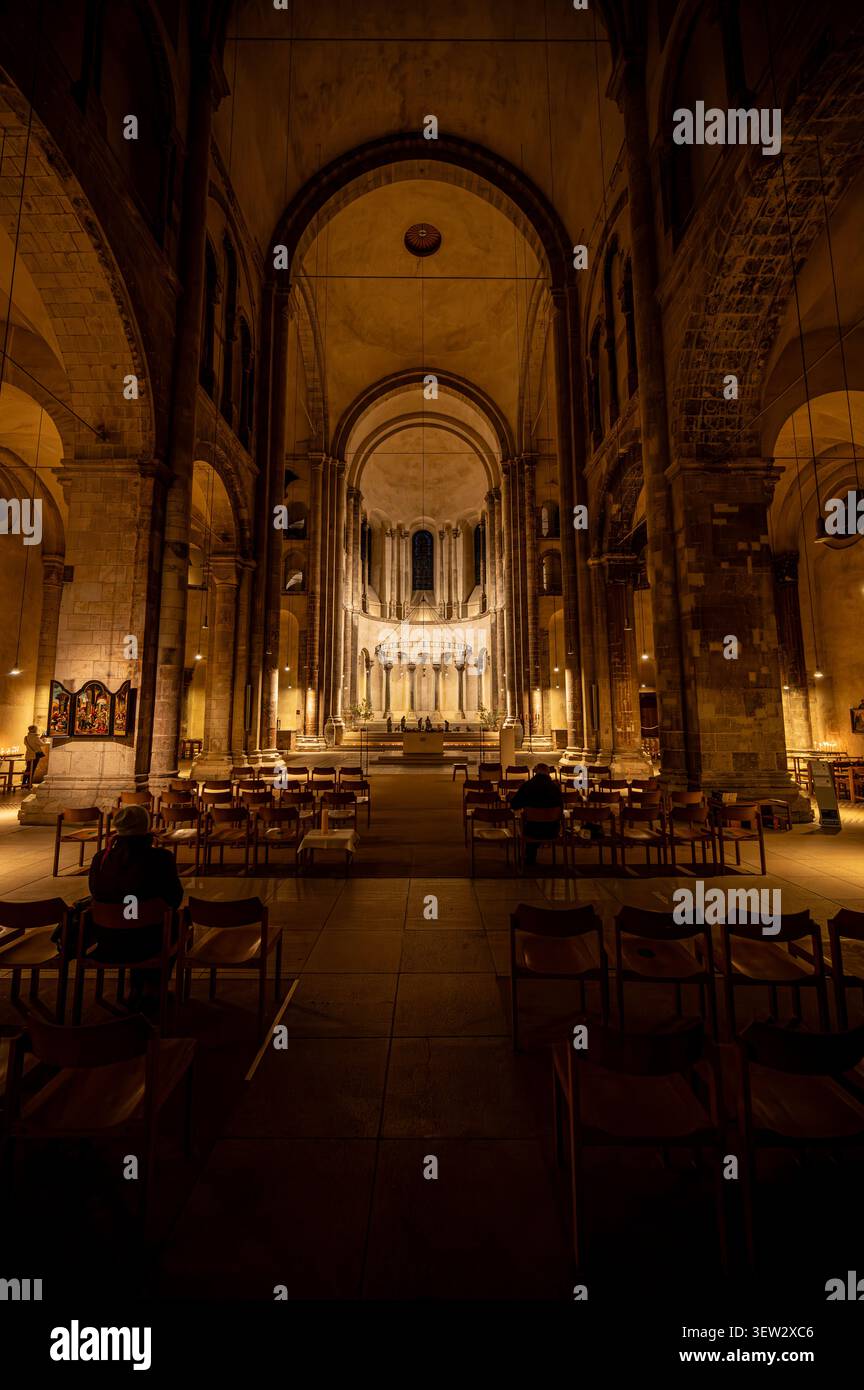Innenansicht des beleuchteten Hauptaltars und der Apsis in der romanischen St. Bartholomäus-Kathedrale in Köln bei Nacht Stockfoto