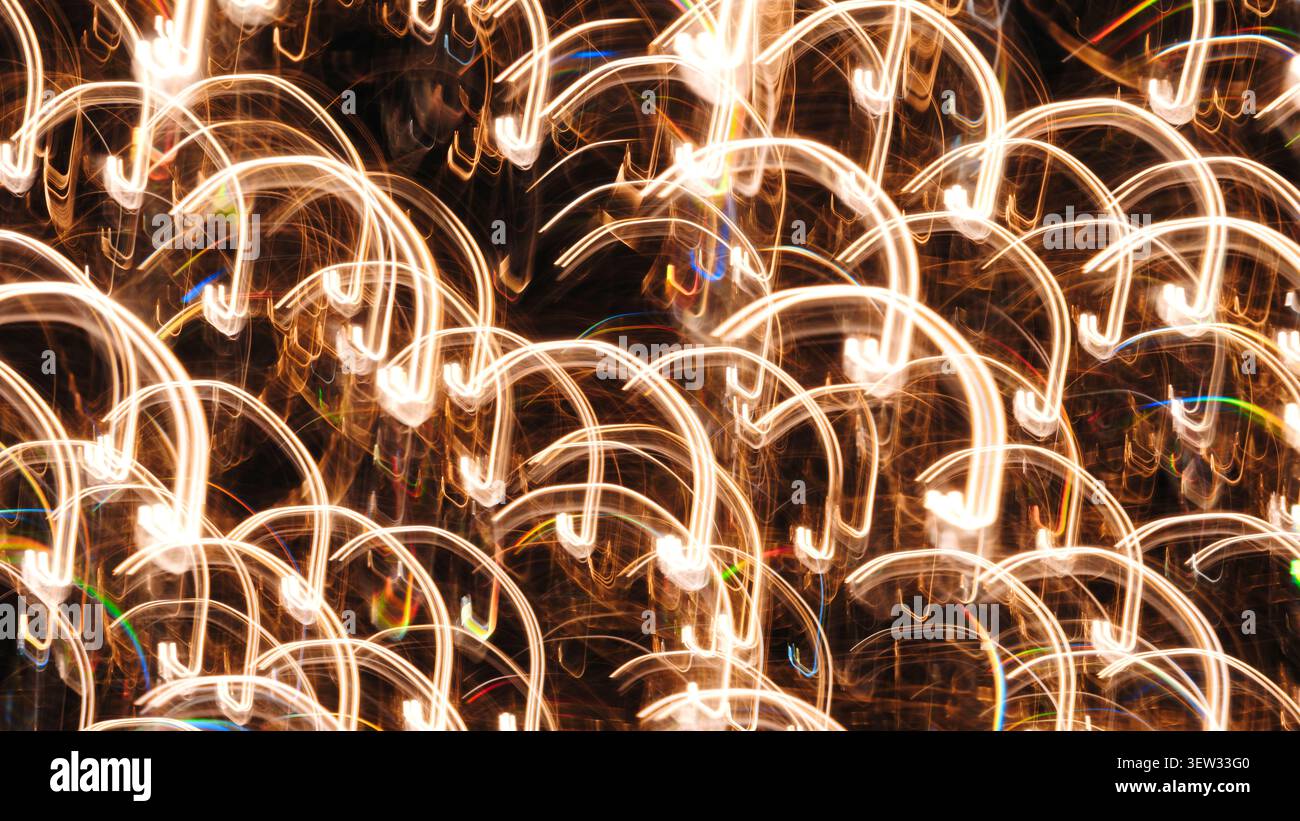 Goldene Streifen tanzen in dunkler Leere. Lichtspuren wirbeln wie flüssige Energie. Abstrakte Muster leuchten vor Wärme. Perfekt für festliche, traumhafte oder technische Zwecke Stockfoto