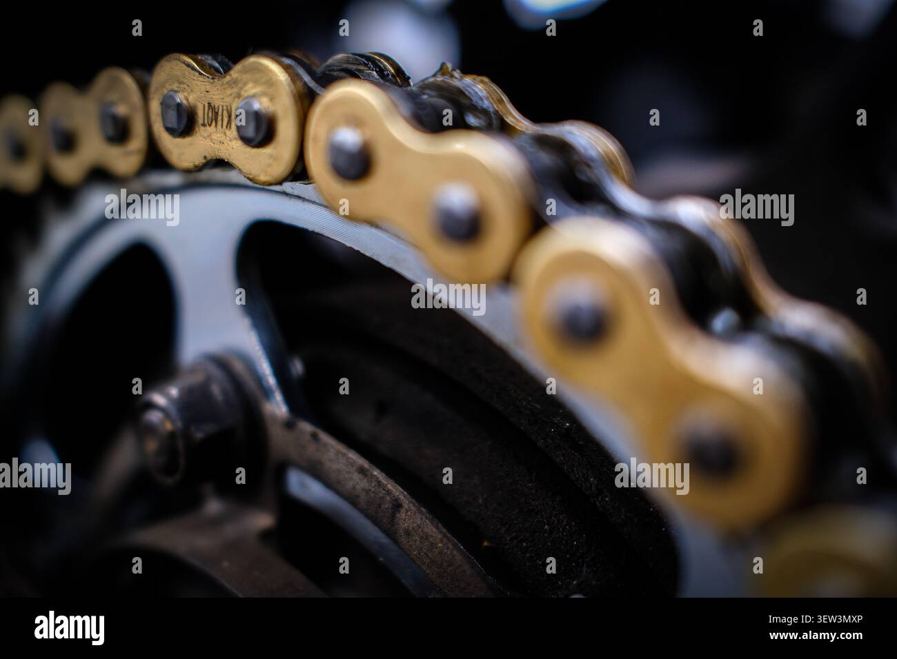 Nahaufnahme einer Motorradkette und Antriebsstrangkomponenten mit geringer Schärfentiefe. Stockfoto