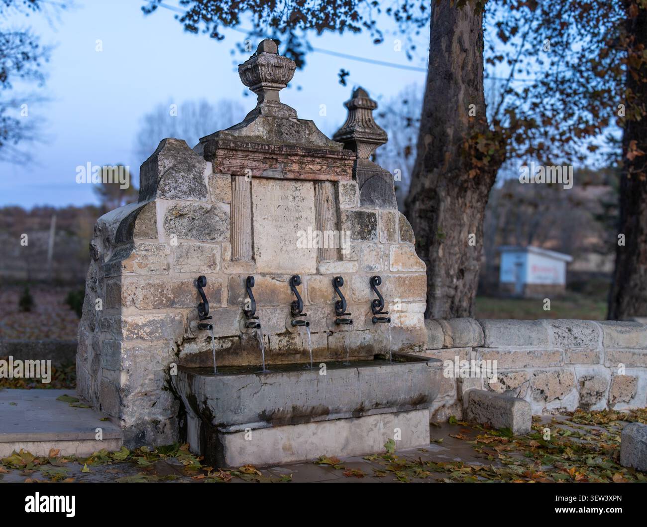 La histórica Fuente de los Cinco Caños en Uclés, Cuenca, España, es una fuente de piedra tradicional y un monumento emblemático. Stockfoto