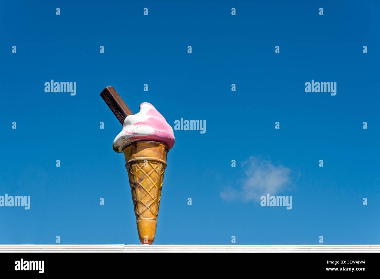 Riesiges Eiskegelschild mit rosafarbenem Erdbeerstrudel und Schokoladenflocke Stockfoto
