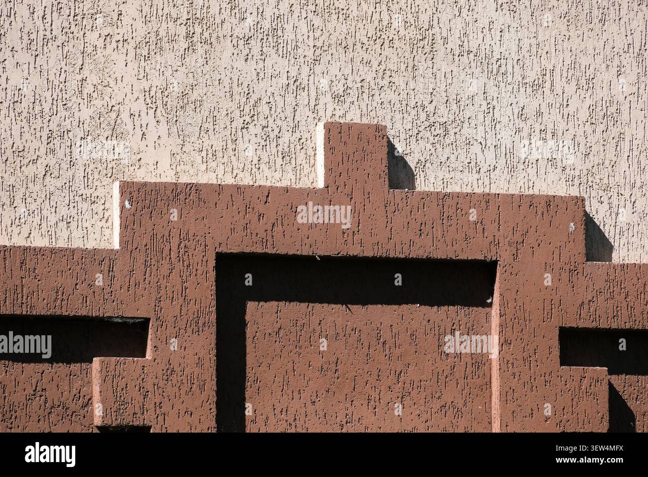 Diese Wand zeigt komplexe braune Muster vor einem hellen Hintergrund. Stockfoto