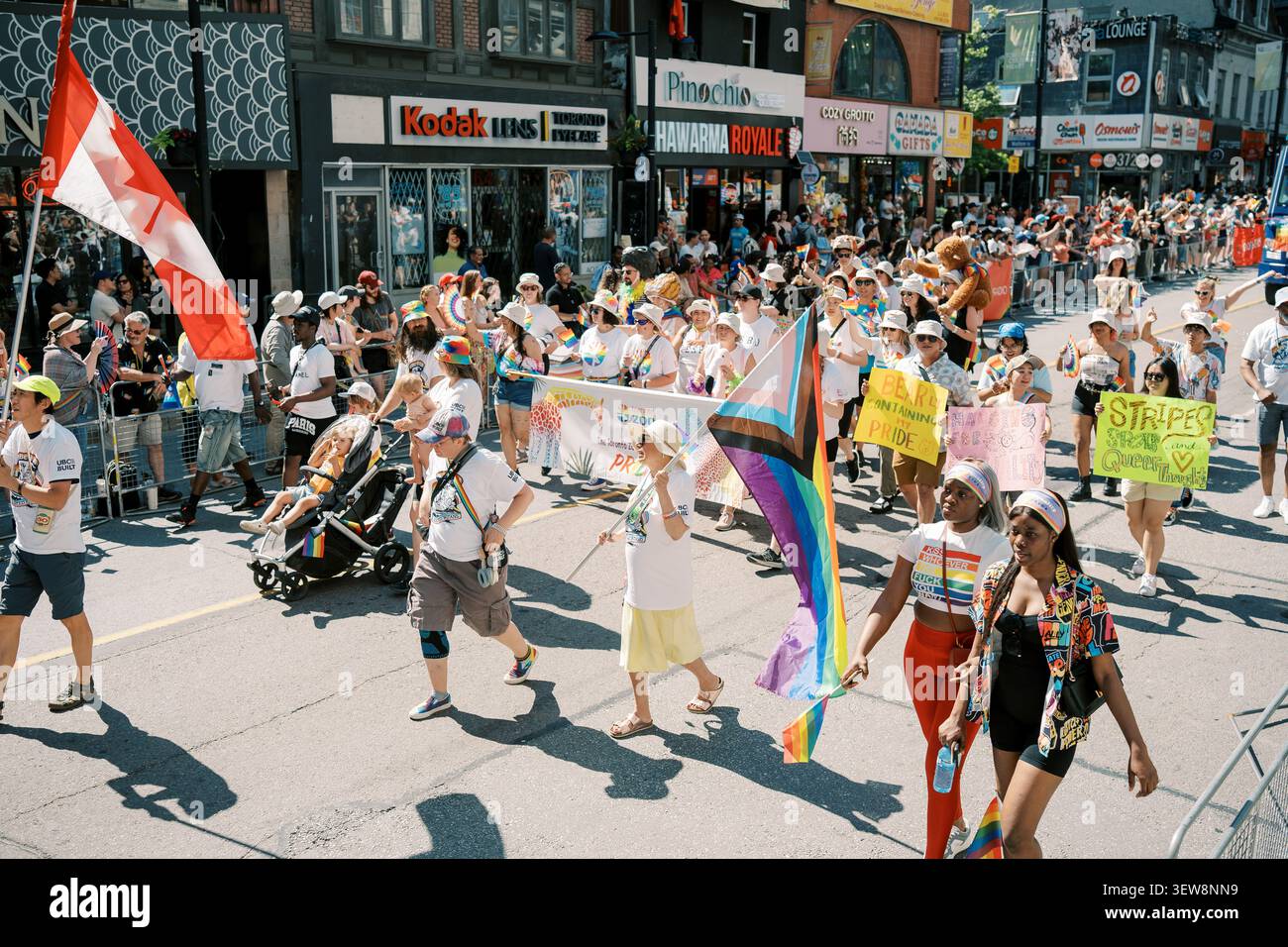 Toronto, Kanada - 29. Juni 2025: Eltern schieben Kinderwagen mit Stolz-Flagge Stockfoto