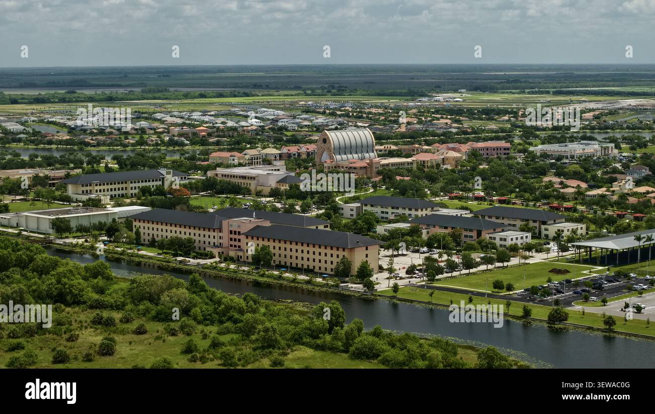Blick aus der Vogelperspektive auf das Oratorium an der Ave Maria University, umgeben von üppigem Grün, Wohnvierteln und einem Kanal in der Ave Maria, Florida, United Stockfoto