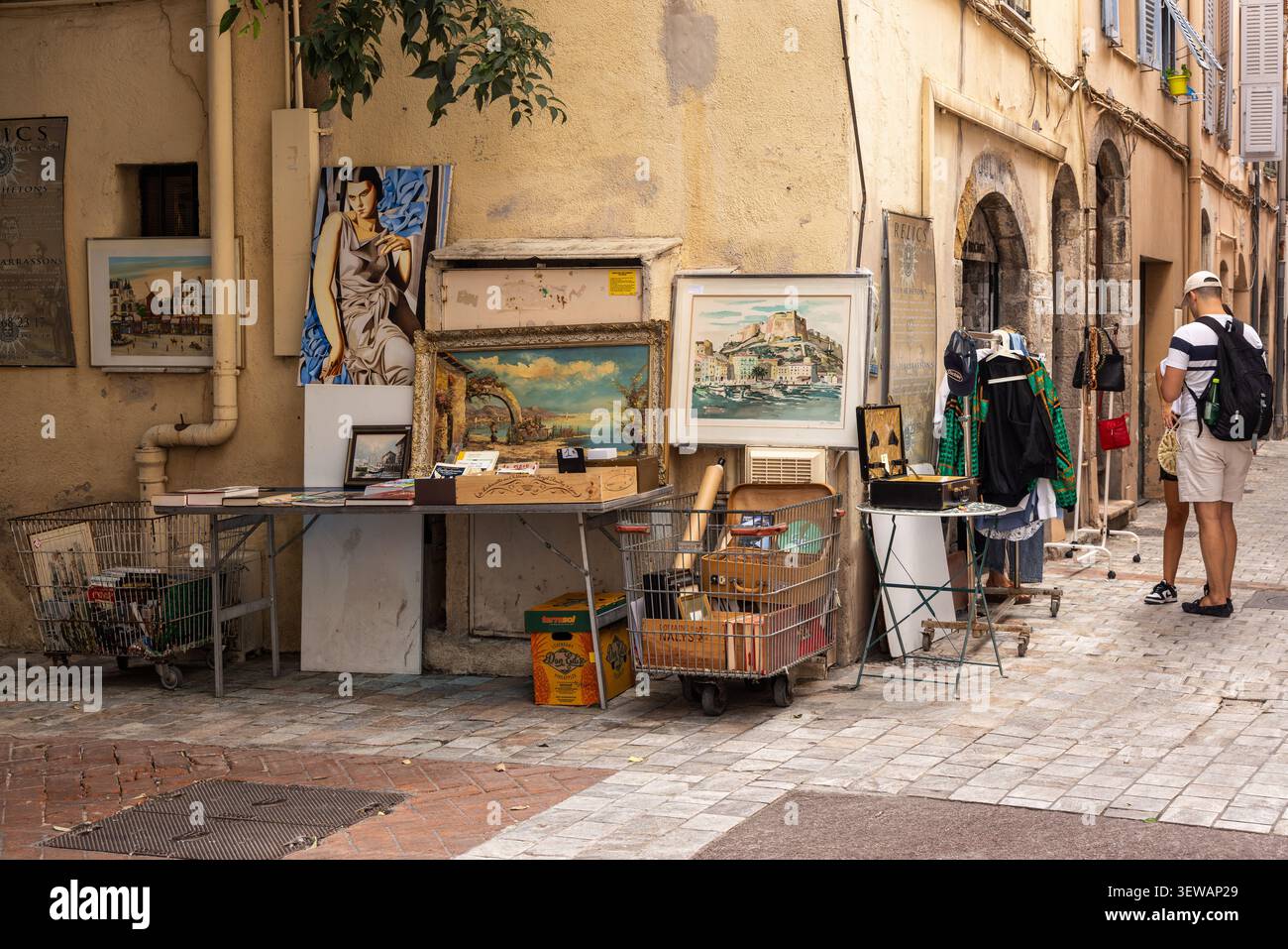 Ein Paar vor dem Antiquitätenladen für Relikte in der Rue de la Miséricorde, Cannes, Alpes-Côte dAzur, Südfrankreich Stockfoto