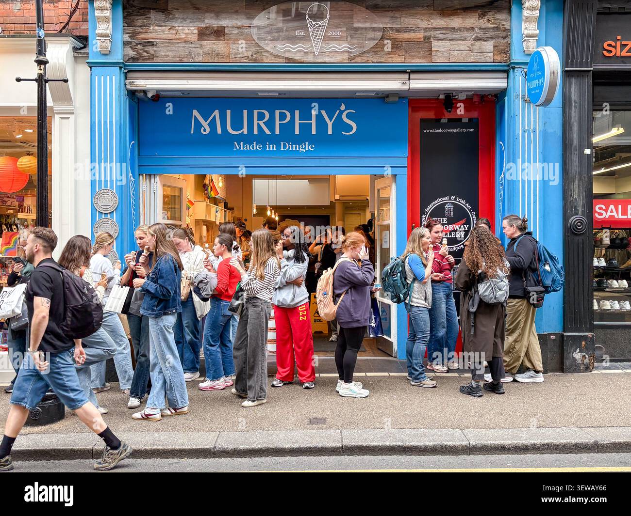 Menschen versammelten sich vor Murphy's Ice Cream Store in Dublin, Irland. Kunden essen Eiskegel vor der Ladenfassade. Stockfoto