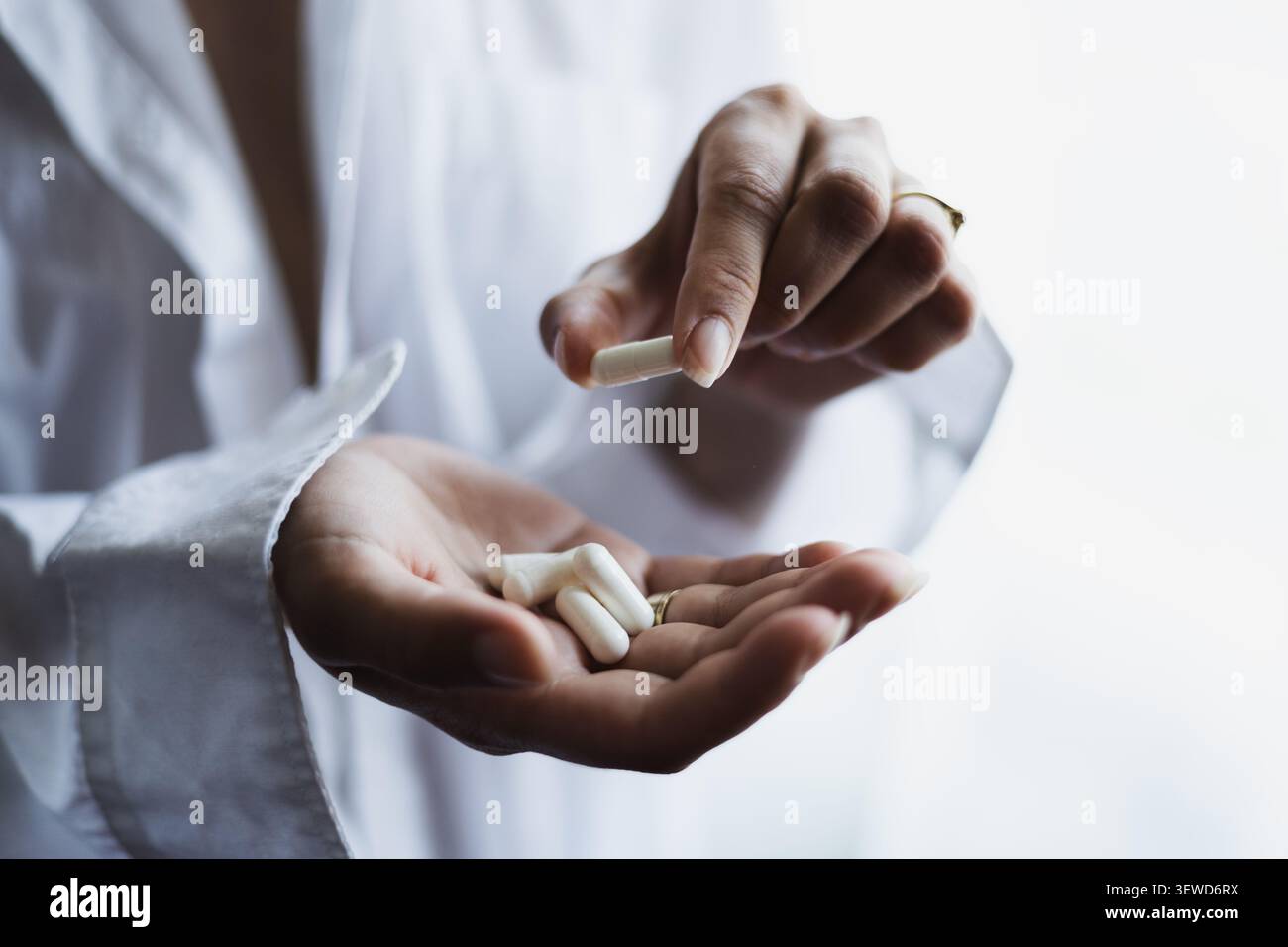 Junge Frau nimmt Pillen am Morgen, täglich Vitamine für Haar, Haut, Körper, natürliche Schönheit und gesunde Lebensweise Stockfoto