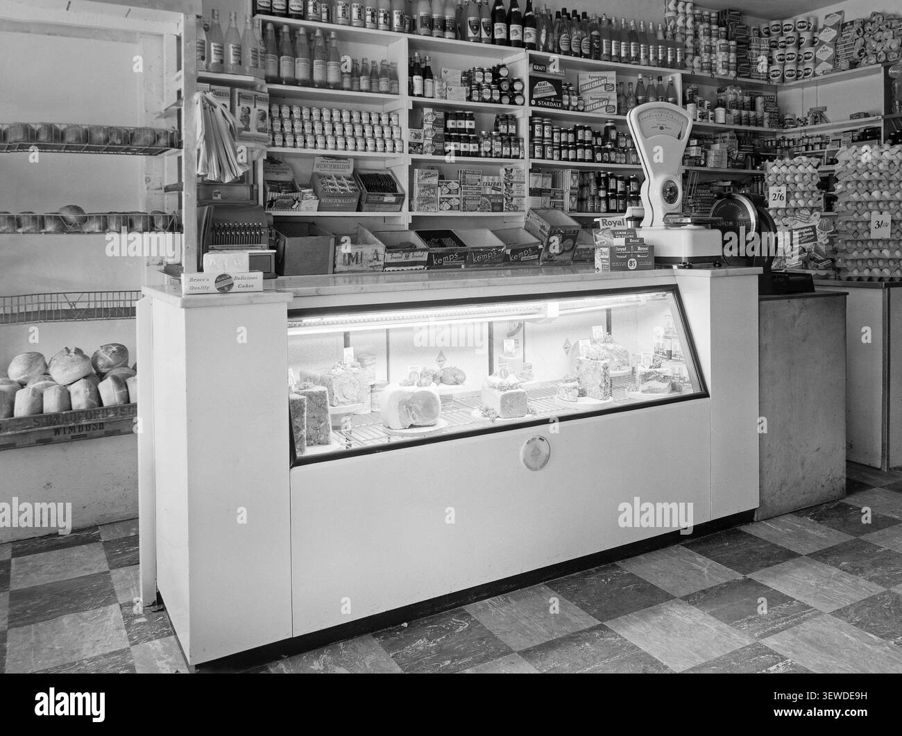In einem britischen Gemischtwarenladen 1954. Verschiedene Lebensmittel aus der Zeit, die in Regalen ausgestellt wurden. Fleischprodukte im Anzeigegerät. Dosen, Flaschen und Gläser mit verschiedenen Produkten. Stockfoto