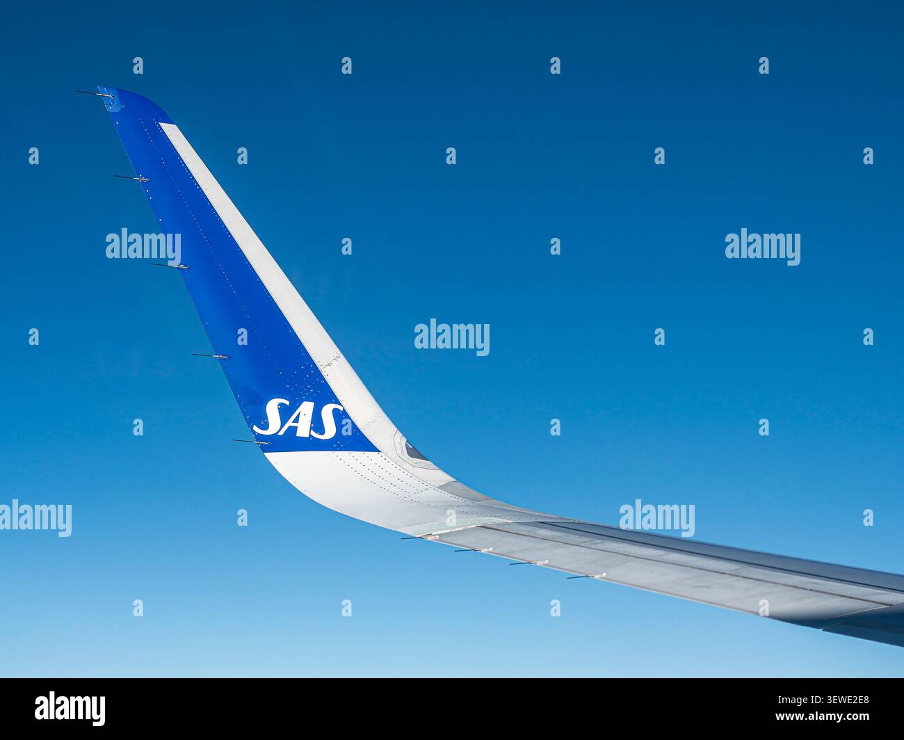 Eine Nahaufnahme eines modernen kommerziellen Flugzeuges Flügelspitze, der in großer Höhe vor einem völlig klaren, leuchtend blauen Himmel segelt Stockfoto