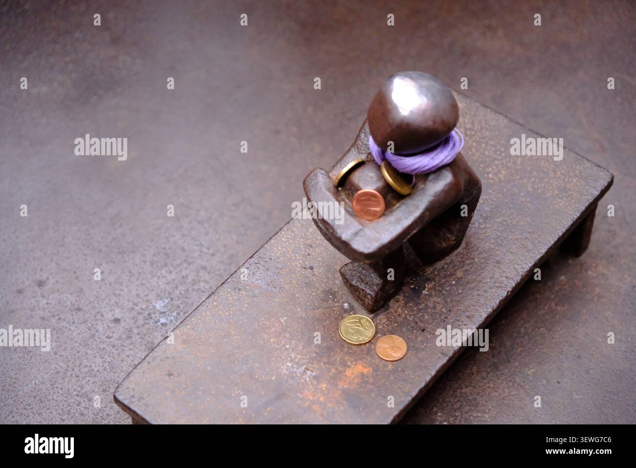 Stockholm, Schweden-27. November 2025: Stockholmer Eiserne-Boy-Statue, der Junge, der auf den Mond schaut, mit Münzen und einem lila Schal. Stockfoto