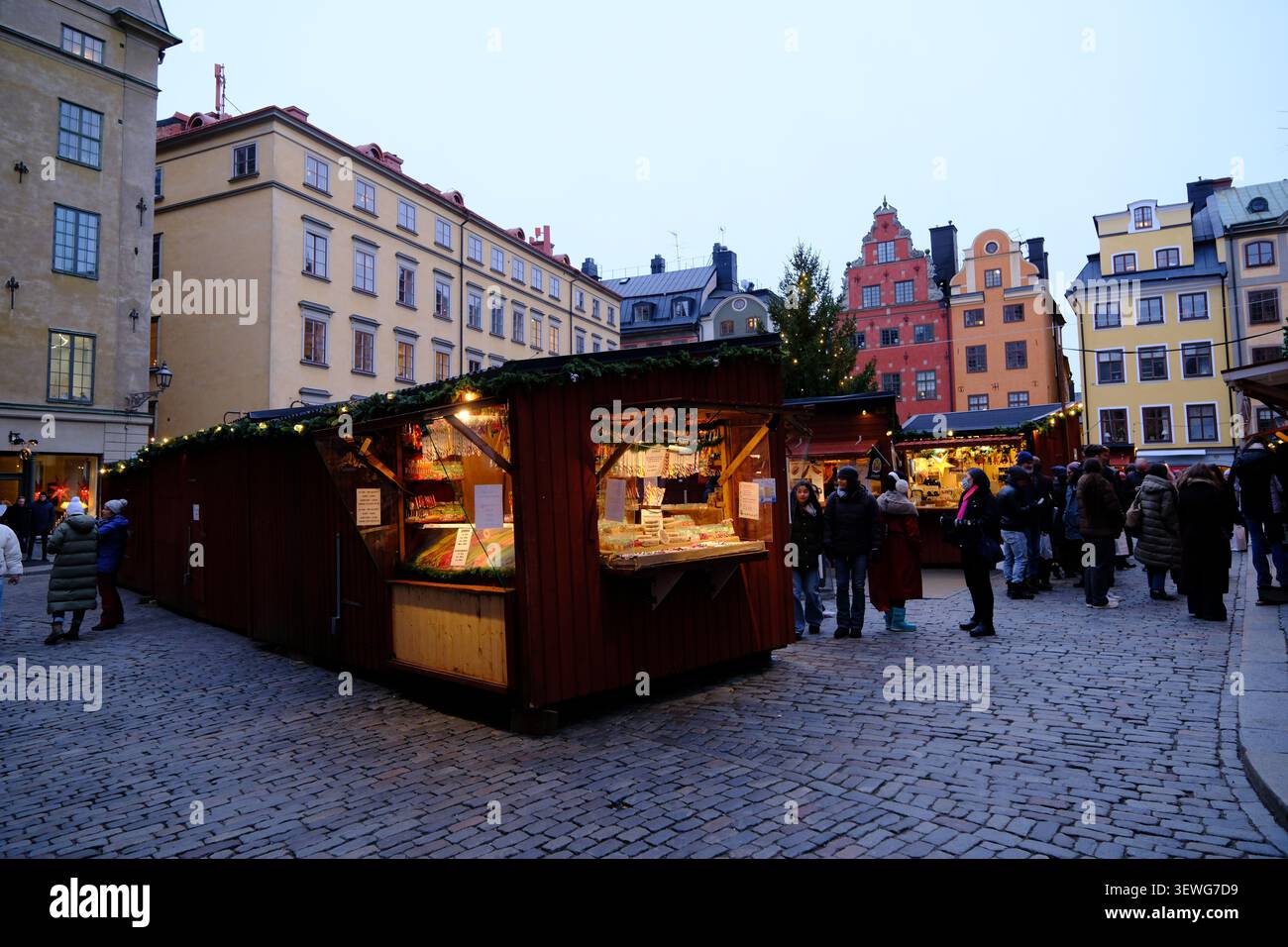 Stockholm, Schweden-27. November 2025: Weihnachtsmarkt Holzbuden mit Touristen in Stortorget, Gamla Stan, Stockholm am Abend. Stockfoto