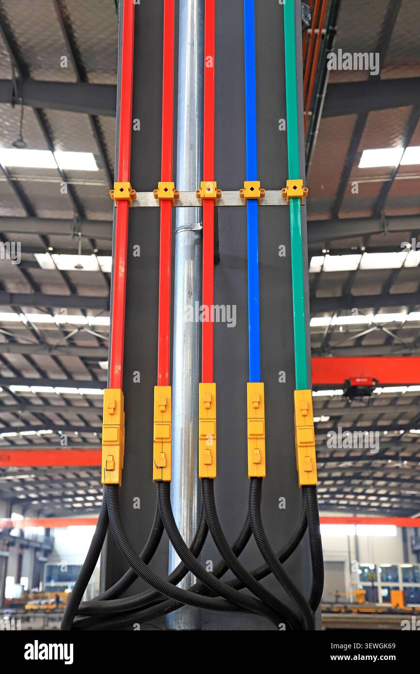 Eine hochauflösende Aufnahme eines Stromverteilungssystems für industrielle Sammelschienen mit farbcodierten (rot, blau, grün) isolierten Kupferkabeln Stockfoto