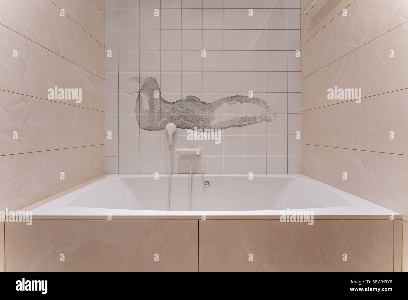 Modernes minimalistisches Badezimmer mit eingebauter weißer Badewanne, beigefarbenen Marmorfliesen und dekorativen Keramikwandgemälden in einem modernen Luxushaus Stockfoto