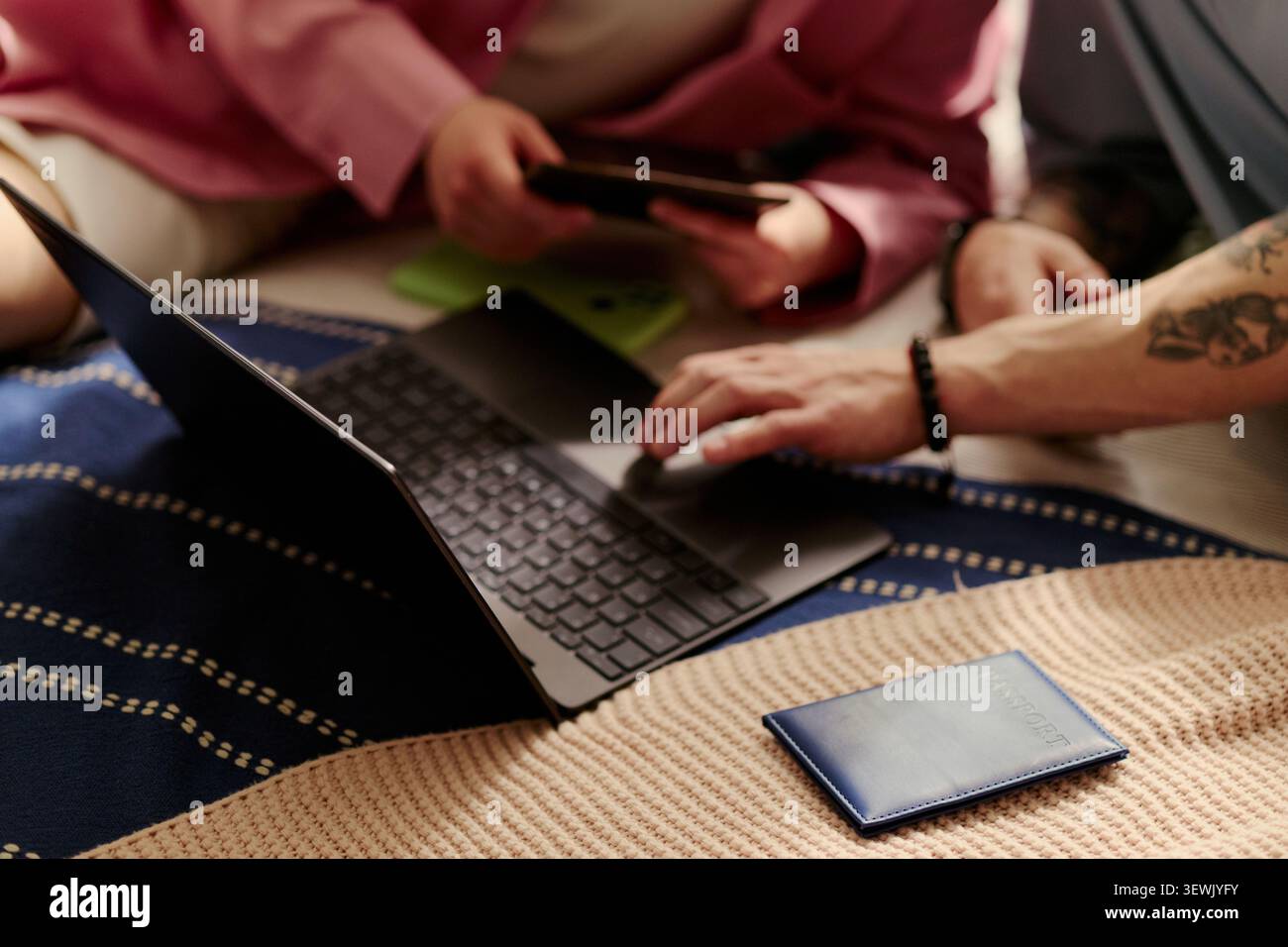 Nahaufnahme junger Erwachsener, die Laptop und Smartphone bei der Planung des Online-Kaufs zu Hause nutzen, mit digitaler Bezahlung und Budgetierung. Ideal für Fintech, E-Commerce und Ferneinkäufe Stockfoto