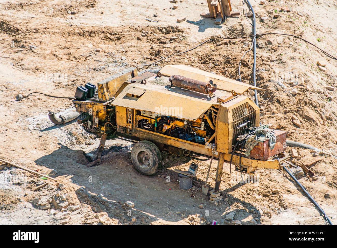 Industriebohrgerät, robuste Maschinen, mobil auf unebenem Gelände, Betonung der Baustellenaktivität, trockene staubige Umgebung, Tageslicht Hintergrund e Stockfoto
