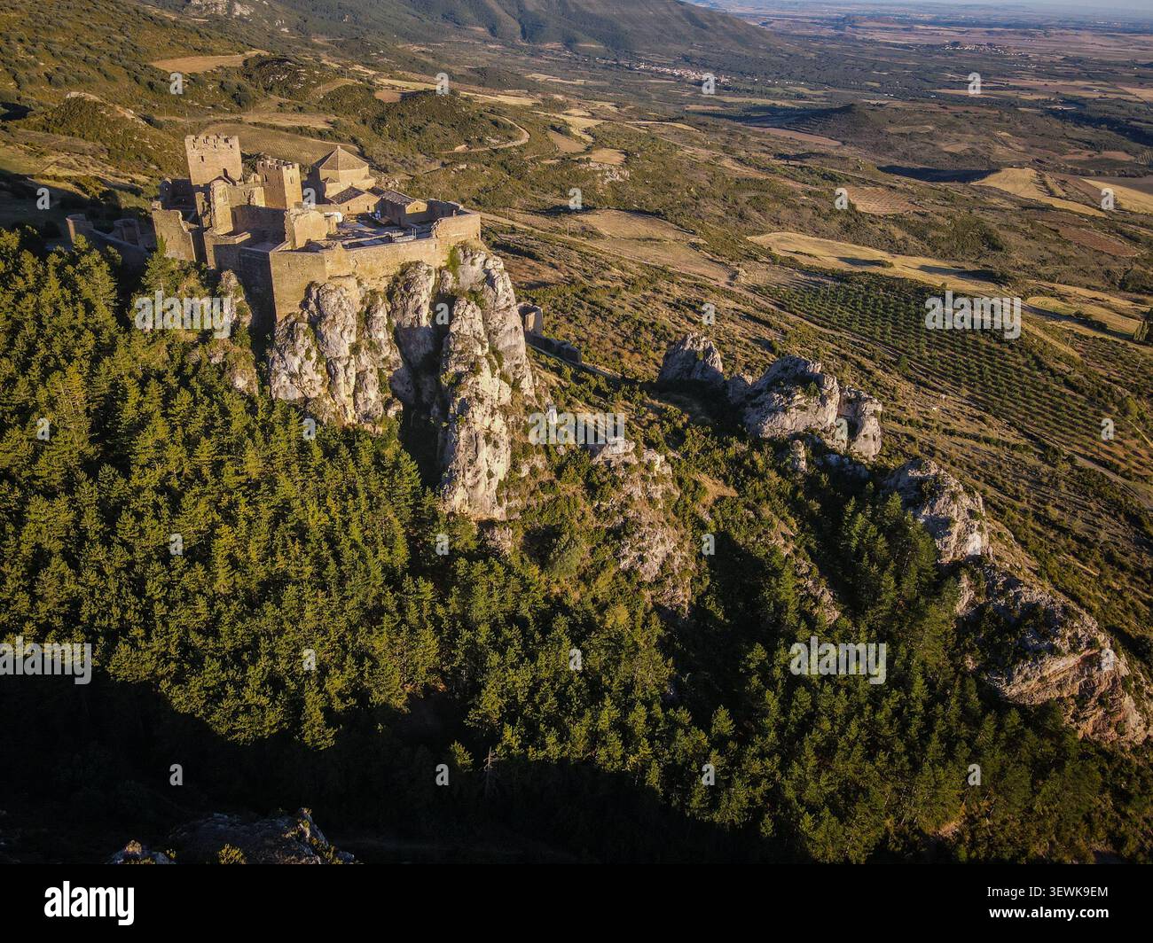 Loarre Castle, eine romanische Festung, befindet sich auf einem Felsvorsprung, umgeben von Kiefern und zerklüftetem Gelände in den Ausläufern der Pyrenäen. Diese Aeria Stockfoto