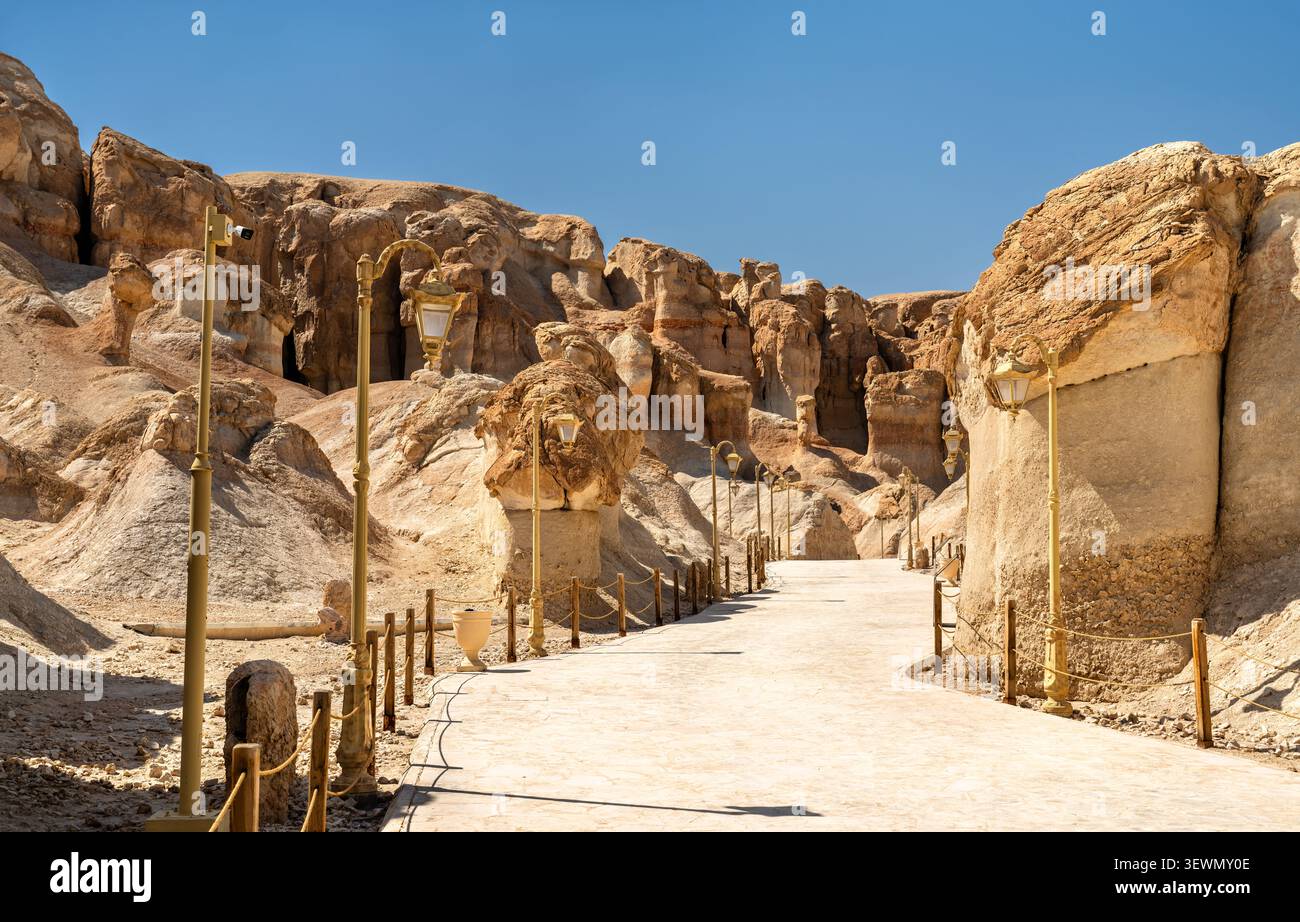 Ein asphaltierter Fußweg schlängelt sich durch die einzigartigen Felsformationen des Al Qarah Berges im Land der Zivilisationen in Al Ahsa, Saudi-Arabien. Stockfoto