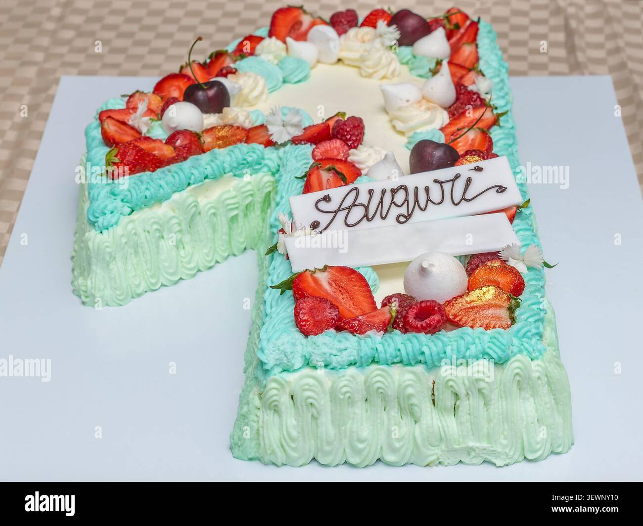 Geburtstagskuchen mit Obst und Baisons in Form der Zahl 1 und des Wortes „Auguri“ (alles Gute zum Geburtstag auf Italienisch) Stockfoto