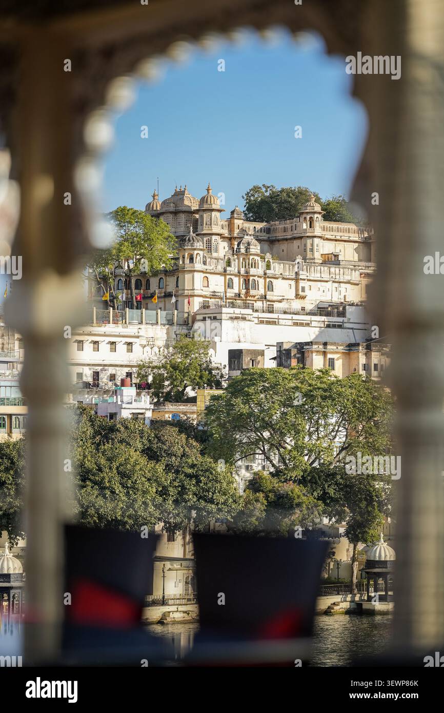 Historischer Palast, Blick durch einen eleganten Steinbogen mit Blick auf den Pichola-See in Udaipur, Rajasthan. Kreative Reisekomposition, die Indien hervorhebt Stockfoto