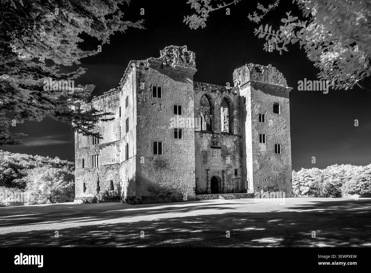 Wardour Castle Wiltshire UK Vorder- und Seitenansicht in dramatischem Schwarzweiß und kunstvoll eingerahmt von Baumlaub Stockfoto