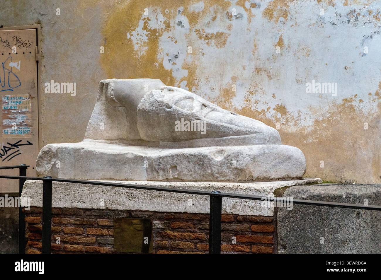 ROM, ITALIEN - 8. MÄRZ 2023: Dies ist ein riesiger Marmorfuß in einer kleinen Gasse der Altstadt, der ein Fragment einer kolossalen Statue während der Blütezeit darstellt Stockfoto
