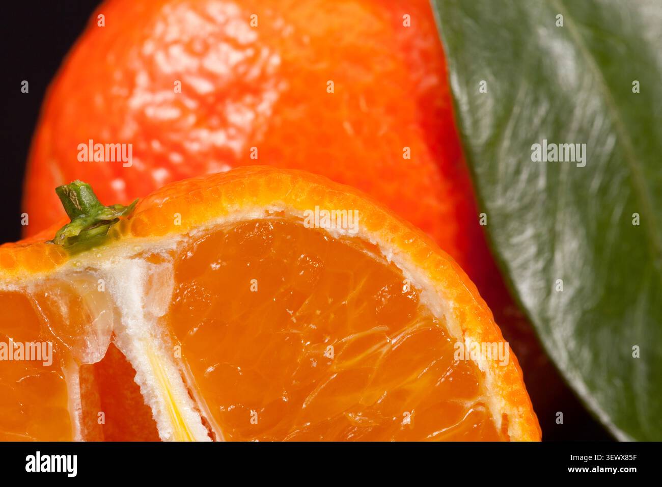 Hintergrund der ganzen Früchte von Mandarine orange mit grünen Blättern Stockfoto