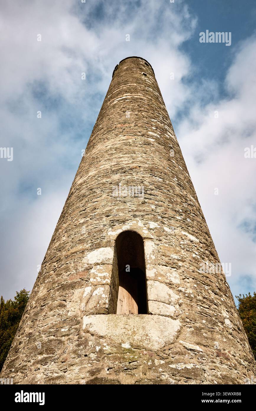 Niedrigwinklige Ansicht des mittelalterlichen Rundturms in Glendalough, Irland Stockfoto