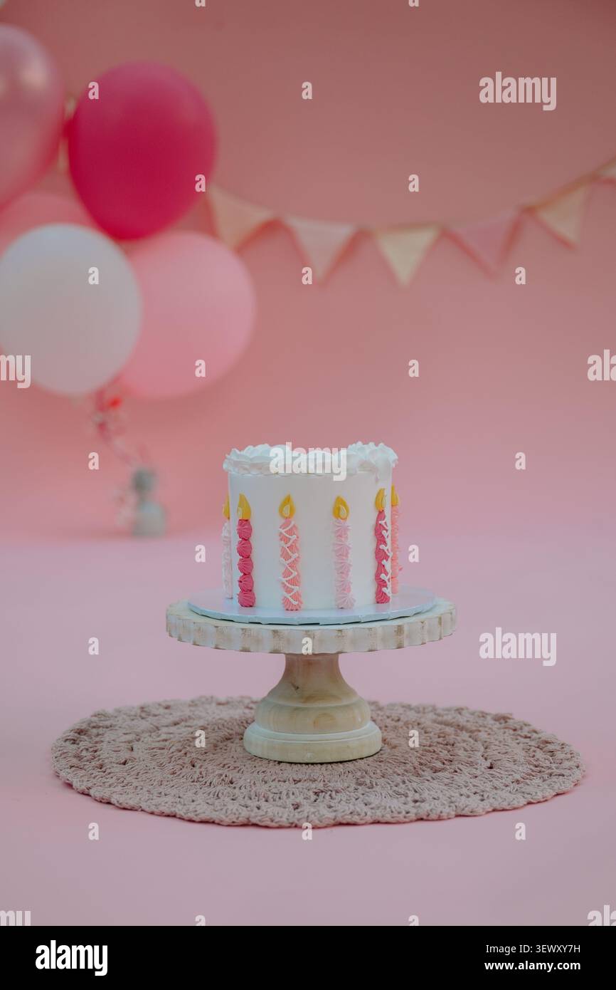 Der erste Geburtstagskuchen zerschmettert mit rosa Dekorationen Stockfoto