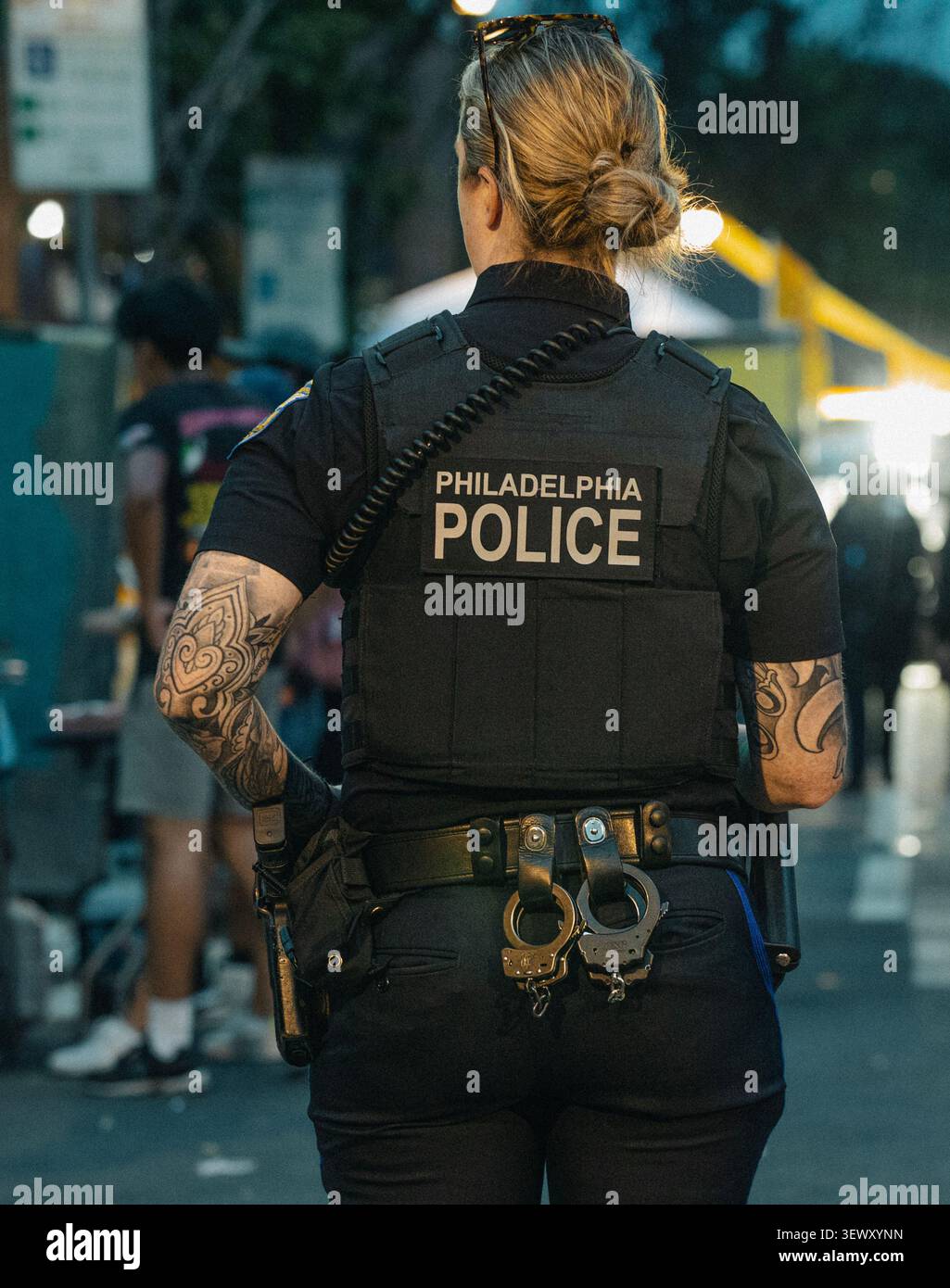 Tätowierte Polizistin auf Patrouille nachts Stockfoto