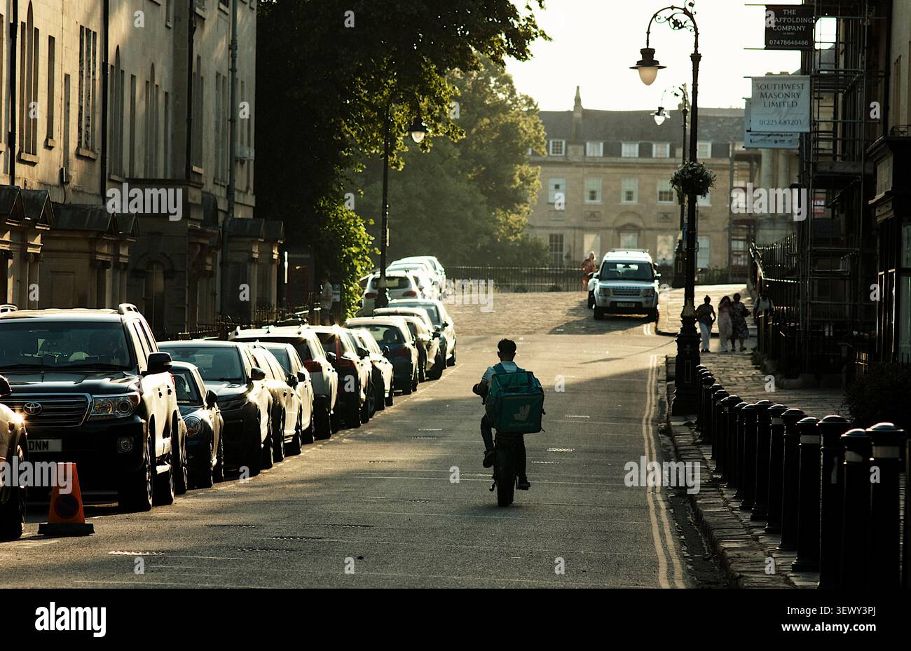 BATH, Großbritannien - 2026/Juni/25: Ein E-Bike-Fahrer mit Essenslieferung in der Brock Street Bath zwischen dem Royal Crescent und dem Circus Stockfoto