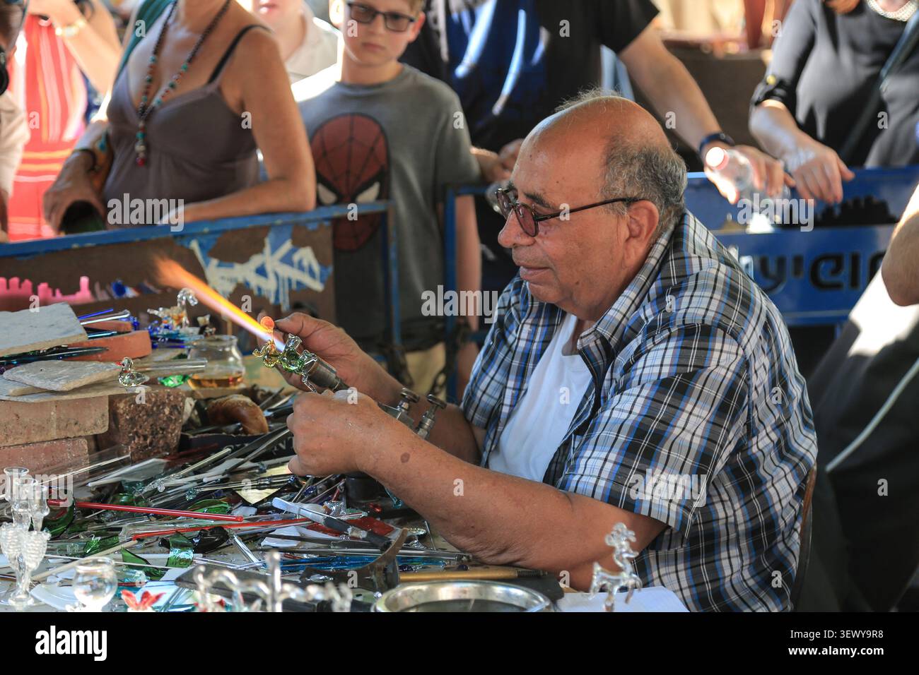 TEL AVIV, ISRAEL - 06. Oktober 2017: Ein Glasbläser formt eine Miniatur-Glasfigur mit einer Fackelflamme, während Zuschauer Nachalat Biny beobachten Stockfoto