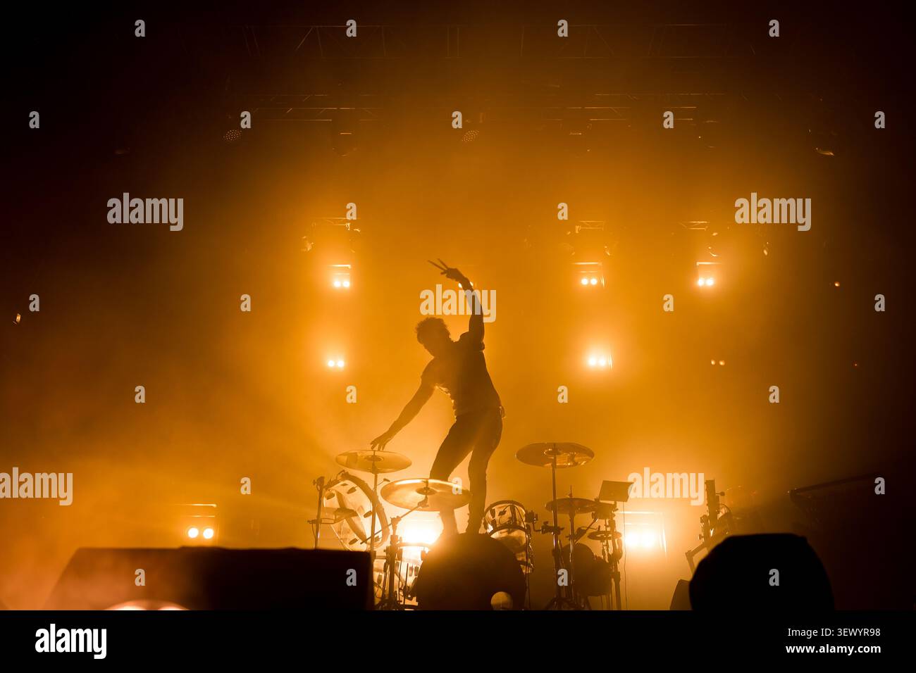 Silhouette eines Schlagzeugers, der auf einem Live-Konzert auf der Bühne Schlagzeug spielt, mit dramatischen Lichtern, die während der Vorstellung auf dem Schlagzeug stehen Stockfoto