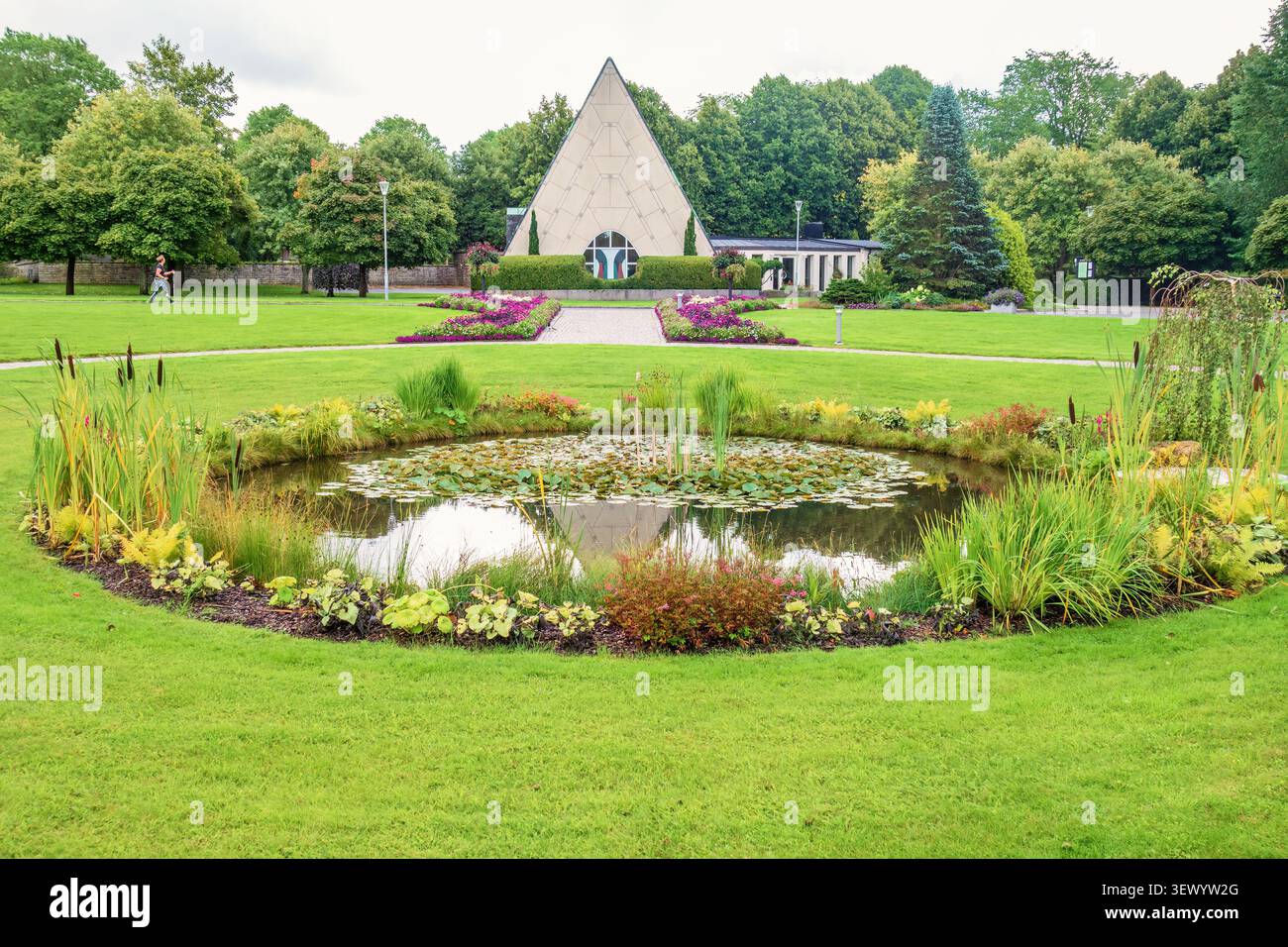 Wasserteich mit Blumen und grünen Pflanzen in einer Kapelle Stockfoto
