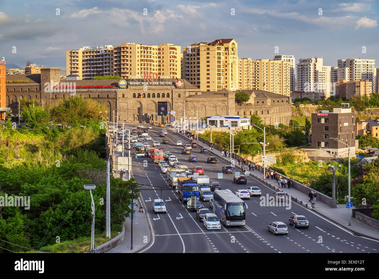 Durch die Stadt fließt eine stark befahrene Stadtstraße mit starkem Verkehr. Moderne Hochhäuser säumen den Horizont Stockfoto