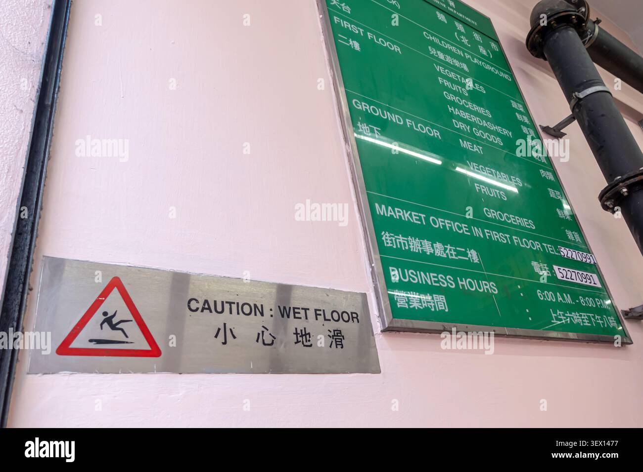 Grünes Schild mit Gebäudeverzeichnis, Layout und Stockwerke eines mehrstöckigen Marktes, Warnschild „Caution Wet Floor“, Bowrington Road Market, HK Stockfoto