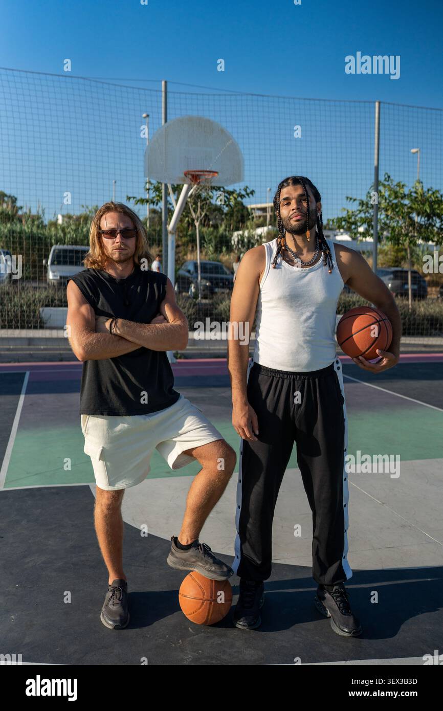Zwei Männer posieren mit Basketball auf dem Platz Stockfoto