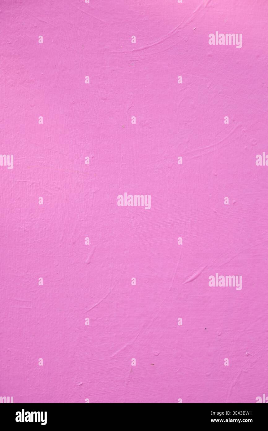 Hellrosafarbene Wand mit glatter Textur in einfacher Umgebung Stockfoto