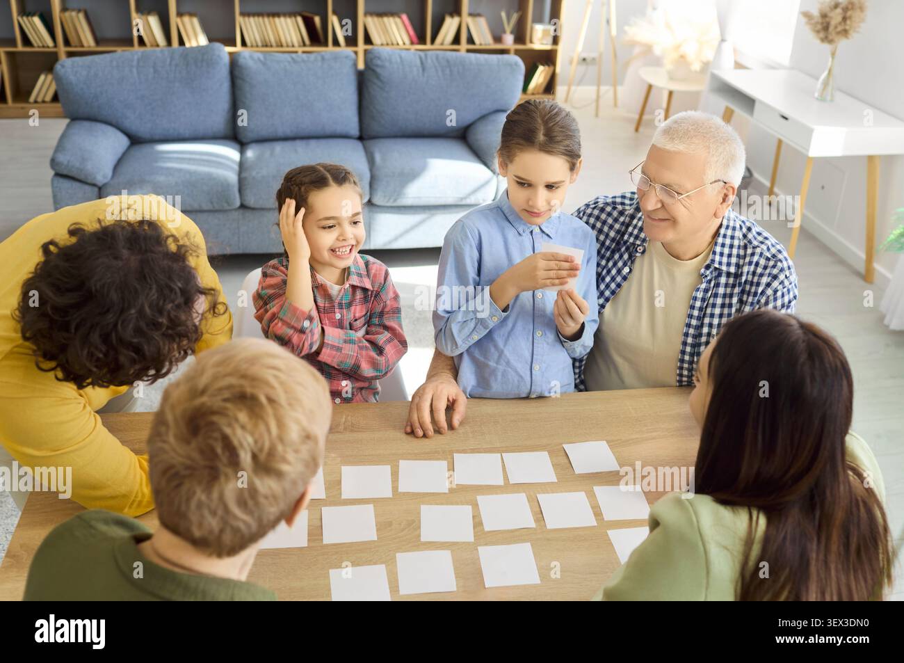 Großvater, Eltern und Kinder spielen gemeinsam zu Hause ein Speicherkartenspiel Stockfoto